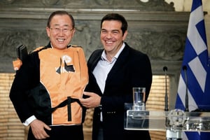 Le secrétaire général de l’ONU Ban Ki-moon (g) en gilet de sauvetage offert par le Premier ministre grec Alexis Tsipras (d) comme un « symbole » des traversées périlleuses des migrants, le 18 juin à Athènes. © Yorgos KONTARINIS/AFP