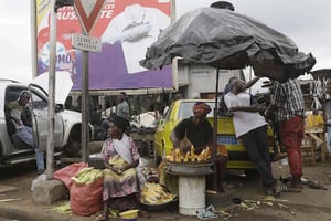 Une femme vend du maïs dans le quartier d’Abobo dans le nord d’Abidjan, en Côte d’Ivoire, en août 2015. © Sunday Alamba/AP/SIPA