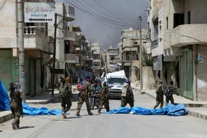 Des membres de forces démocratiques syriennes dans une rue de Minbej en Syrie, le 7 août 2016/ © AFP/DELIL SOULEIMAN