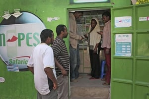 Des clients attendent devant un comptoir M-Pesa à Nairobi, en août 2011. © Sayyid Abdul Azim/AP/SIPA