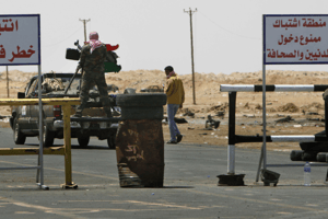 Des rebelles libyens bloquant l’entrée d’Ajdabiya avec un panneau « zone de guerre, interdit aux citoyens et journalistes », le 23 avril 2011 © Nasser Nasser/AP/SIPA