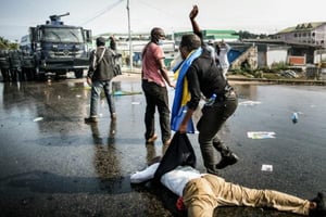 Un partisan de l’opposant gabonais Jean Ping évacue un blessé lors d’une manifestation dénonçant la réélection d’Ali Bongo, le 31 août 2016 à Libreville. © AFP