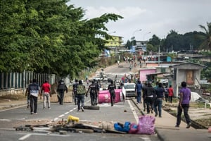 Des policiers gabonais démontent les barricades d’opposants à Ali Bongo dans les rues proches de l’Assemblée nationale, le 1er septembre 2016 à Libreville. © MARCO LONGARI/AFP
