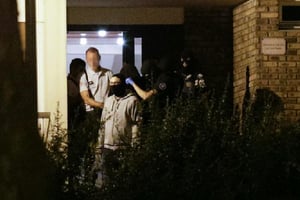 Une femme, la tête recouverte d’une couverture, est emmenée par les policiers le 8 septembre 2016 à Boussy Saint Antoine. © GEOFFROY VAN DER HASSELT/AFP