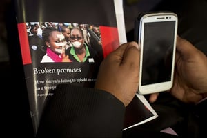 Un journaliste tient une copie d’un rapport sur la liberté de la presse au Kenya, le 15 juillet 2015. © Ben Curtis/AP/SIPA