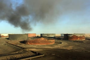 De la fumée s’échappe de terminaux de stockage pétroliers en Libye après des combats, le 9 janvier 2016 près de Ras Lanouf. © STRINGER/AFP