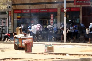 La foule court se cacher pour échapper aux affrontements entre manifestants et police anti-émeute le 27 septembre 2016 à Harare. © Tsvangirayi Mukwazhi/AP/SIPA