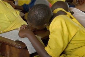 Une fillette écrit sur un cahier pendant la classe, en Ouganda, en avril 2008. © Matt Lucht/CC/Flickr