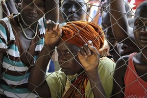 Une femme se tient au grillage d’un camp de réfugiés de l’ONU. © Justin Lynch/AP/SIPA