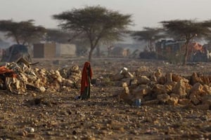 Une Somalienne marche à travers un camp de déplacés près de Qhardho, une ville de la région de Bari dans le nord-est de la Somalie, frappée par la famine, en mars 2017. © Ben Curtis/AP/SIPA