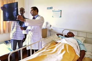 Chirurgien au chevet d’un patient nigérian, à l’Apollo Hospital de Chennai (Inde du Sud). © Manjunath KIRAN/AFP