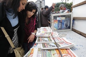 Des jeunes filles devant des exemplaires de journaux à Tunis en 2011. © Christophe Ena/AP/SIPA