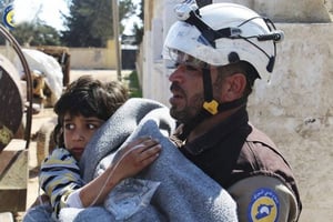 Un volontaire de la Défense civile syrienne secourant un enfant blessé, à Khan Cheikhoun, dans le nord-est du pays, le 4 avril 2017. © PLANET Pix/ZUMA-REA
