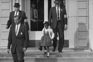 Des policiers fédéraux escortent Ruby Bridges, alors âgée de six ans, face à une foule raciste opposée à son entrée dans une école blanche, le 14 novembre 1960. © Anonymous/AP/SIPA