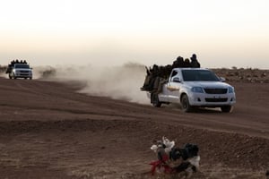 Un convoi de passeurs transportant des migrants vers la Libye, près d’Agadez, au Niger, en février 2016. © Photo : OIM