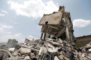 Un yéménite sur les décombres du maison touchée par des frappes aériennes, le 26 août, dans un quartier résidentiel de Sanaa. © AFP