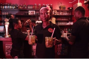 Une serveuse dans un bar d’Accra au Ghana, portant des cocktails d’alcool en 2013. © Christian Thompson/AP/SIPA