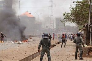 Des forces de police en Guinée, devant une scène d’émeute à Conakry, la capitale guinéenne, en avril 2015. © Youssouf Bah/AP/SIPA