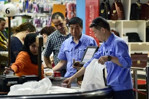 Des travailleurs chinois à la caisse de la grande surface UNO, au centre commercial et de loisir de Bab Ezzouar, à l’est d’Alger, en mai 2015. © Omar SEFOUANE/JA