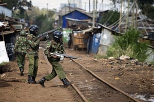 Des soldats en train de patrouiller, armes automatiques en mains, dans le bidonville de Kibera, à Nairobi. © Darko Bandic/AP/SIPA