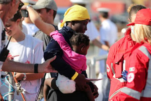 Une femme débarque avec un enfant en Sicile, le 13 octobre 2017, après avoir été secourue par l’ONG SOS Méditerranée. © Igor Petyx/AP/SIPA