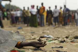 Une foule observe une victime de tirs, en janvier 2011 dans le quartier d’Abobo, à Abidjan. © Rebecca Blackwell/AP/SIPA