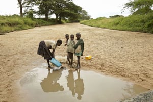 Des femmes lavent leur linge dans une rivière presqu’à sec, en Ouganda, le 18 octobre 2017. © Adelle Kalakouti/AP/SIPA