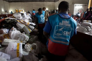 Des agents de la Céni accumulent les bulletins de vote dans un entrepôt à Kinshasa le 3 Décembre 2011. © Gwenn DUBOURTHOUMIEU