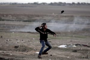 Un jeune Palestinien en train de lancer des pierres sur des soldats israéliens, lors de heurts avec des soldats israéliens, le 7 décembre 2017. © Khalil Hamra/AP/SIPA