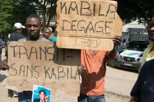Des militants de l’opposition brandissent des pancartes avec des slogans anti-Kabila le 30 novembre 2017 à Kinshasa. © JUNIOR KANNAH / AFP