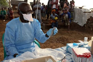 Un chercheur prélevant des échantillons sur un rongeur dans un village en Sierra Leone en février 2011. © Reuters