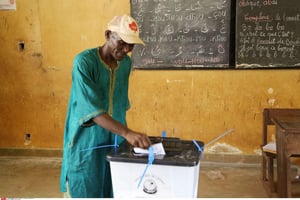 Un homme met son bulletin dans l’urne à l’occasion des élections présidentielles guinéennes de 2015. © Youssouf Bah/AP/SIPA