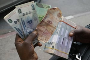 Des francs congolais dans les mains d’un cambiste clandestin, en juillet 2017 à Kinshasa. © Baudouin Mouanda pour JA