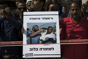 « D’un « abri » au Rwanda à la marchandise en Lybie », lit-on sur la pancarte, lors d’une manifestations de migrants est-africain en Israël, le 22 février. © Tsafrir Abayov/AP/SIPA