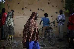 Des Maliens devant un poste de police de Gao lourdement bombardé en février 2013 par des combattants de Mujao. © Jerome Delay/AP/SIPA