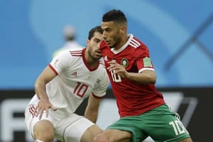 Le Marocain Younes Belhanda à la lutte avec l’Iranien Karim Ansarifard, en match de poule du Mondial 2018, le 15 juin à Saint-Pétersbourg, en Russie. © Andrew Medichini/AP/SIPA