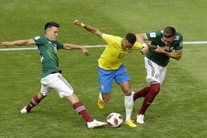 Le joueur brésilien Neymar pris en tenaille entre deux défenseurs mexicains, le 2 juillet 2018. © Sergei Grits/AP/SIPA