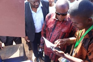 Mamadou Bah présente l’application au président guinéen, Alpha Condé, à Nzérékoré (mai 2018). © Banki Group