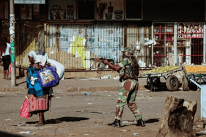 Un soldat zimbabwéen met en joue le 1er août 2018 un femme à Harare, où des affrontements ont opposé forces de l’ordre un partisans de l’opposition, qui dénoncent des fraudes après les élections générales de lundi. © Zinyange AUNTONY/AFP