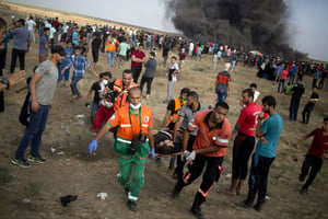 Des sauveteurs évacuent un blessé, lors d’affrontements entre Palestiniens et forces de l’ordre israéliennes à la frontière Gaza-Israël le 3 août 2018. © Khalil Hamra/AP/SIPA
