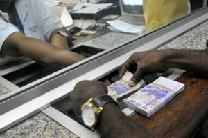 Retrait d’argent à un guichet de banque en Afrique de l’Ouest (illustration). © Olivier pour JA
