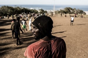 Un migrant lors d’un match de foot entre Maliens et Ivoirienssur la colline Gourougou, à Nador, au Maroc, en 2014. © Daniel Etter/REDUX-REA
