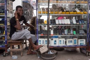 Un homme vend des téléphone portable dans le quartier commercial de Ganhi à Cotonou, au Bénin, le 26 février 2016. © Gwenn Dubourthoumieu pour J.A.