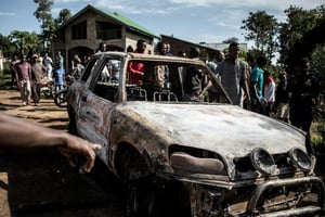 Des Congolais regardent une voiture incendiée au cours d’une attaque attribuée aux rebelles ougandais ADF à Beni, dans l’est de la RDCongo, le 11 novembre 2018. © afp.com – John WESSELS