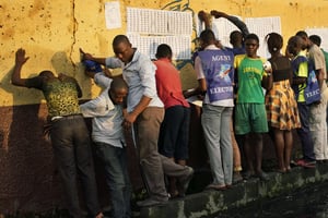 Les fonctionnaires électoraux enregistrent la liste des inscriptions des électeurs sur le mur de l’école primaire Les Anges à Kinshasa, au Congo, alors que les électeurs commencent à vérifier leur nom, le dimanche 30 décembre 2018. © Jerome Delay/AP/SIPA