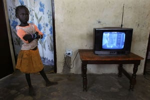 Une fillette à côté d’un écran de télé, à Cherif Lo, près de Tivaouane au Sénégal, en 2005. © SCHALK VAN ZUYDAM/AP/SIPA