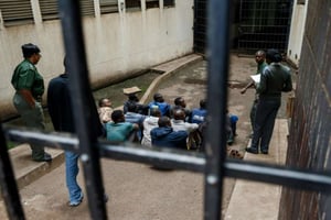 Des gardiens de prison surveillent le 16 janvier 2019 à Harare des hommes arrêtés après les violentes manifestations contre la hausse du prix de l’essence au Zimbabwe. © AFP