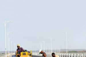 Infrastructures routiËres au Mali en Afrique : construction du troisiËme pont sur le Niger par une entreprise chinoise prËs de Bamako, Sotuba (23/05/11). Ouvriers posant du bitume sur le pont. Les investissements chinois et la coopÈration Chine Afrique se dÈveloppent fortement.<br>175259985 ; BTP; chantier; ouvrage d’art; investissements | Road infrastructure in Mali in Africa: building the third bridge over the Niger by a Chinese company near Bamako, Sotuba (23/05/11). Workers laying asphalt on the bridge. Chinese investment and cooperation between China and Africa are growing strongly.<br>175259985†[AT] ; © Xinhuanet / Andia.fr