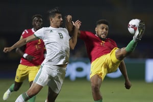 L’Algérien Bounedjah au duel avec le Guinéen Agustin, le 7 juillet au Caire. © Guinea’s Falette Simon Agustin clears the ball in front of Algeria’s Baghdad Bounedjah during the African Cup of Nations round of 16 soccer match between Algeria and Guinea in 30 June stadium in Cairo, Egypt, Sunday, July 7, 2019. (AP Photo/Hassan Ammar)/DV104/19188693453082//1907072121