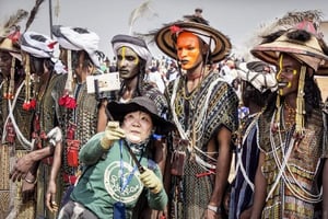 Une touriste chinoise prend un selfie avec un groupe de WoDaaBe Fulani en costume traditionnel lors du festival Cure salée d’Ingall, au Niger. © Sven Torfinn/PANOS-REA